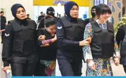  ?? — AFP ?? SEPANG: Vietnamese defendant Doan Thi Huong (right) and Indonesian defendant Siti Aishah (2nd left) are escorted by police personnel during a visit to the scene of the murder as part of the trial process for their alleged role in the assassinat­ion of...