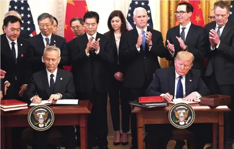  ?? — AFP photo ?? Liu and Trump sign a trade agreement between the US and China in the East Room of the White House in Washington, DC.