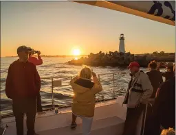  ?? COURTESY OF JON ORLIN ?? Guests enjoy sunset views — and wine or beer tasting — aboard a Chardonnay II cruise in Santa Cruz.
