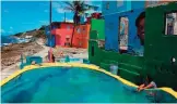  ??  ?? A woman touches the water of a makeshift pool in the neighborho­od of La Perla.