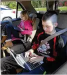  ??  ?? Home-schoolers Ellis Knight, 12, and his sister Regan, 9, get their homework done in the back seat after their mother Jamie Knight brought them to the church so they could get Wi-Fi access.