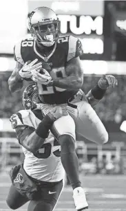  ?? EUROPEAN PRESS AGENCY ?? Patriots running back James White catches a touchdown pass over the Texans’ Benardrick McKinney on Saturday.