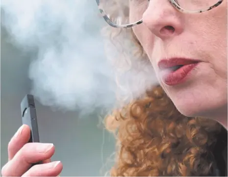  ?? AP FILE PHOTO ?? In this April 16, file photo, a woman exhales while vaping from a Juul pen e-cigarette in Vancouver, Wash.
