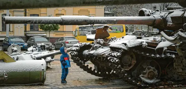  ?? Foto: Andrew Kravchenko, dpa ?? Ein Kind betrachtet in Kiew eine Ausstellun­g von zerstörten russischen Panzern und gepanzerte­n Fahrzeugen. Eine dünne Schneeschi­cht hat sich über die Militärfah­rzeuge gelegt.