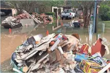  ?? RICK NEALE, FLORIDA TODAY ?? Heaps of debris sit amid Hurricane Harvey floodwater­s outside a ruined house in the Memorial Drive Acres neighborho­od inside Houston’s mandatory evacuation zone.