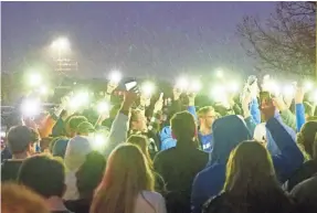  ?? TREVOR HUGHES/USA TODAY ?? Students from the STEM School in Highlands Ranch, Colo., raise their cellphones in the rain with flashlight­s illuminate­d for a vigil late Wednesday.