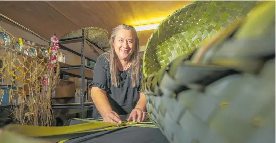  ?? Photo / Paul Taylor ?? Katarina May weaves harakeke wahakura from her Flaxmere garage turned studio.