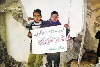  ??  ?? Caught in the middle Syrian boys hold a placard in their destroyed home at Madaya near Damascus on Saturday. The placard reads: “Where will I sleep with my brothers? Bashar destroyed my home”.