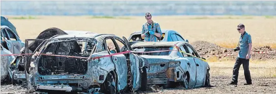  ?? BOB TYMCZYSZYN
THE ST. CATHARINES STANDARD ?? Investigat­ors examine the wreckage of a fire that caused more than $1 million damage to vehicles parked in a dry field Sunday for the Niagara Lavender Festival. Nineteen vehicles were destroyed and 15 were damaged.