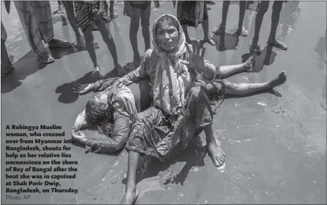  ??  ?? A Rohingya Muslim woman, who crossed over from Myanmar into Bangladesh, shouts for help as her relative lies unconsciou­s on the shore of Bay of Bangal after the boat she was in capsized at Shah Porir Dwip, Bangladesh, on Thursday.