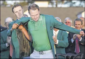  ?? CURTIS COMPTON / CCOMPTON@AJC.COM ?? Jordan Spieth presents Danny Willett the green jacket after his Masters victory last year.
