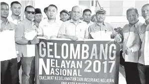  ??  ?? RAZAK, Arsit dan para pegawai dari LKIM memegang baner sebagai simbol pelancaran Gelombang Nelayan Nasional 2017 bagi program Taklimat Keselamata­n dan Insuran Nelayan bagi PNK kawasan Kota Kinabalu.