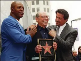  ?? CHRIS PIZZELLO — THE ASSOCIATED PRESS FILE ?? Sylvester Stallone, right, and his “Rocky” co-star, former profession­al football player Carl Weathers, left, pose with producer Irwin Winkler at the Walk of Fame ceremony for Winkler in the Hollywood section of Los Angeles.