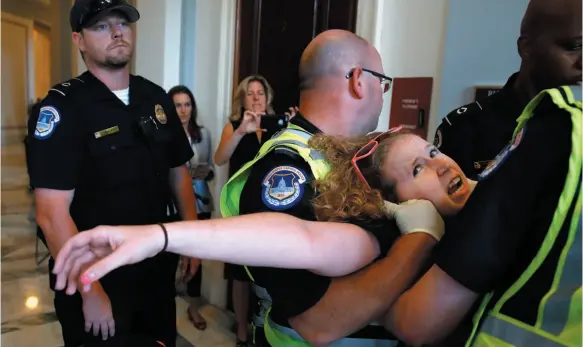  ?? AP PHOTO ?? Stephanie Woodward, of Rochester, N.Y., who has spina bifida and uses a wheelchair, is removed from a sit-in at Senate Majority Leader Mitch McConnell’s office as she and other disability rights advocates protest proposed funding caps to Medicaid on...