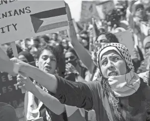  ?? ANTRANIK TAVITIAN/DFP ?? Sasan Hado, right, waves the Palestinia­n flag during a rally in support of Palestine at the Dearborn Police Department on May 18, 2021. Arab Americans, for the first time, now make up a majority of the residents of Dearborn, according to new census data.