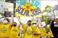  ?? ?? Solar workers march in Los Angeles Jan. 13 at a rally against a proposed change to financial incentives in California for home rooftop solar.