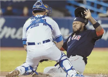  ?? AP PHOTO ?? REAL DOWNER: Hanley Ramirez gets tagged out at home by Blue Jays catcher Luke Maile during the third inning of last night’s game in Toronto. Maile also hit a pair of home runs, including the two-run walkoff blast in the bottom of the 12th to hand the...