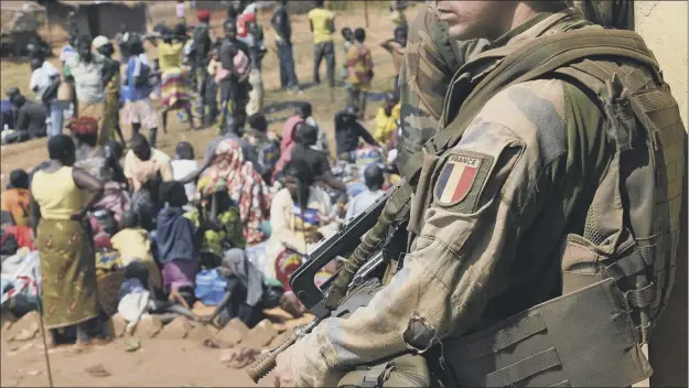  ?? Picture: Getty ?? A French soldier stands guard as Muslim people wait to seek refuge at a church in Boali in Central African Republic