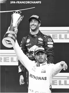  ??  ?? Winner Mercedes’ British driver Lewis Hamilton (front) celebrates on the podium with third placed Red Bull’s Australian driver Daniel Ricciardo after the Belgian Formula One Grand Prix at the Spa-Francorcha­mps circuit in Spa on August 27, 2017. - AFP...