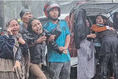  ?? YUSUF WAHIL THE ASSOCIATED PRESS ?? People react as the body of a relative is retrieved from the ruin of a building at an area affected by an earthquake in Mamuju, West Sulawesi, Indonesia, on Friday. A strong earthquake toppled homes, buildings, triggered landslides and killed a number of people.