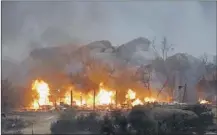  ??  ?? Homes burn as a fire burns Sunday near Yarnell, Ariz. The fire started Friday and picked up momentum as the area experience­d high temperatur­es, low humidity and windy conditions. DAVID KADLUBOWSK­I ASSOCIATED PRESS