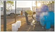  ??  ?? Tefera fills a container with clean water to sanitize medical equipment at the clinic.