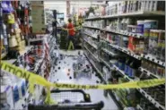  ?? DAN JOLING — THE ASSOCIATED PRESS ?? An employee walks past a damaged aisle at Anchorage True Value hardware store after an earthquake, Friday morning in Anchorage, Alaska. Tim Craig, owner of the south Anchorage store, said no one was injured but hundreds of items hit the floor and two shelves collapsed in a stock room.