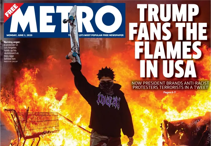  ?? RINGO H.W. CHIU/AP ?? Burning anger: A protester in Los Angeles holds up his skateboard as fires rage behind him