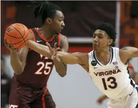  ?? MATT GENTRY/THE ROANOKE TIMES VIA THE ASSOCIATED PRESS ?? Virginia Tech’s Justyn Mutts, left, has the ball tipped from him by Virginia’s Ryan Dunn in the first half of Saturday’s game in Blacksburg Va..