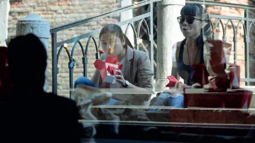  ??  ?? Asporto Una coppia di turiste orientali mangia una pizza seduta su uno dei ponti di Venezia