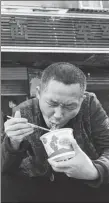  ?? GUO ZHIHUA / FOR CHINA DAILY ?? A resident tucks into a bowl of hot dry noodles in Wuhan on April 9 for the first time in 76 days.