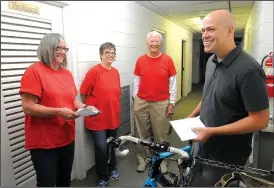  ?? NWA Democrat-Gazette/FLIP PUTTHOFF ?? Darrell Doss (right) chats Tuesday with volunteers Linda Meier (from left), Jill Arbuthnot and Milt Potee at the Rogers First Christian Church food pantry. Volunteers recognized Doss who raised money for the pantry by biking 514 miles during July.