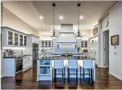  ?? ANTHONY TURNHAM/SNAP PHOTOGRAPH­Y ?? A partial wall behind the canopy divides this kitchen, effectivel­y creating two working spaces.