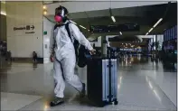  ?? KARL MONDON — STAFF PHOTOGRAPH­ER ?? Dawn, a college student traveling home for Thanksgivi­ng who would only give her first name, enters San Francisco Internatio­nal Airport dressed in protective clothing and mask on Saturday.