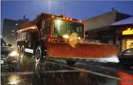  ?? FRANK FRANKLIN II — THE ASSOCIATED PRESS ?? A sanitation truck fitted with a plow treats Lefferts Boulevard in the Queens borough of New York as snow starts to fall, Wednesday, Dec. 16, 2020.