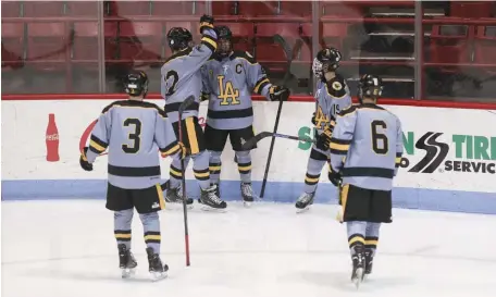  ?? NICOLAUS CZARNECKI PHOTOS / HERALD STAFF ?? LIGHTING THE LAMP: Boston Latin’s Brendan Butler, center, celebrates his goal with teammates, from left, Aidan Farley, Austin Kelly, Cullen Lacey and James Tobin as the Dragons take on the O’Bryant Tigers on Tuesday night.