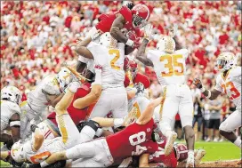  ?? KEVIN C. COX / GETTY IMAGES ?? Bo Scarbrough leaps over Shy Tuttle (2) and other Tennessee defenders for one of his two touchdowns during Alabama’s 604-yard offensive barrage.