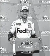  ?? MATT SULLIVAN/GETTY ?? Denny Hamlin poses with the pole award Saturday at Dover Internatio­nal Speedway.