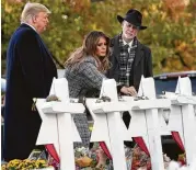  ?? Saul Loeb / AFP / Getty Images ?? President Donald Trump and first lady Melania Trump, alongside Rabbi Jeffrey Myers, place stones and flowers on a memorial to the victims.