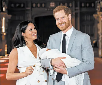  ?? GETTY ?? Prince Harry, Duke of Sussex, and Meghan, Duchess of Sussex, stand with their newborn son, Archie, in St George’s Hall at Windsor Castle on May 8 in England.