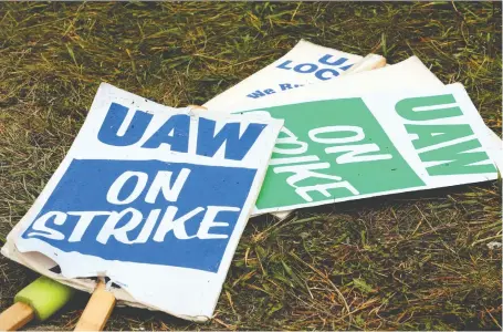  ?? JEFF KOWALSKY/AFP VIA GETTY IMAGES ?? United Auto Workers picket signs are pictured on the ground outside the GM Detroit-hamtramck facility in Detroit on Wednesday. The accord between GM and the UAW may end the union’s first national walkout against the carmaker in a dozen years.
