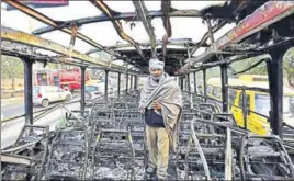 ?? SANJEEV VERMA/HT PHOTO ?? Ranvir Singh, conductor of a Haryana Roadways bus that was torched by Karni Sena activists near Bhondsi in Gurgaon on Wednesday, stands amid the wreckage.