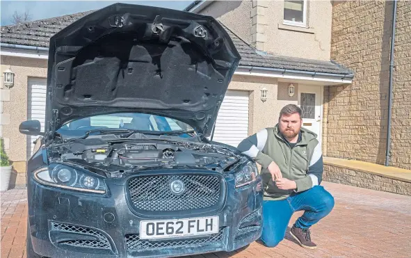  ??  ?? Mike Jones, pictured with his vandalised Jaguar, is offering a “healthy reward” to find the vandal who destroyed his cars in his driveway.
