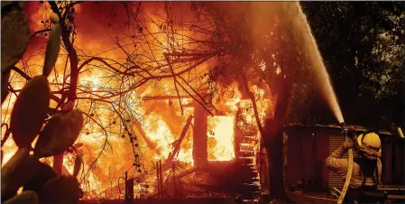  ?? NOAH BERGER — THE ASSOCIATED PRESS FILE ?? A firefighte­r sprays water on a burning home as the Kincade Fire burns through the Jimtown community of unincorpor­ated Sonoma County on Oct. 24, 2019.