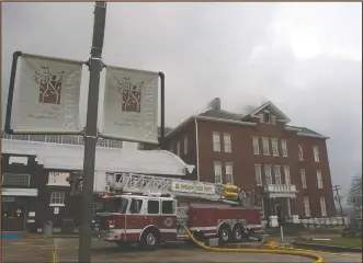  ?? Photos by Terrance Armstard/News-Times ?? Fire: The smoldering roof of the South Arkansas Community College Adminisrat­ion Building can be seen as El Dorado firefighte­rs work to put out a lingering fire that began during Friday night's storms.