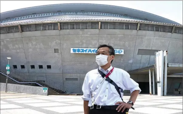  ?? (AP/Chisato Tanaka) ?? Olympic volunteer Atsushi Muramatsu poses for a photo Thursday in front of Sekisui Heim Super Arena, which was used as a morgue after the 2011 earthquake, also known as the Great East Japan Earthquake, in Rifu, Japan.