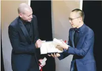  ?? (Eric Gaillard/Reuters) ?? CO-WINNERS OF the Jury Prize director Nadav Lapid (left) and director Apichatpon­g Weerasetha­kul accept their award yesterday.