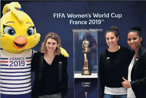  ??  ?? AMBIENTE PREVIO. Mariette Pichon (Francia), Carly Lloyd (EE UU) y Laura Georges (Francia) posan con la mascota y la Copa del Mundo 2019.