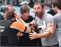  ?? AP PHOTO ?? Police try to calm a man who crossed over a police line at the scene of a shooting in Liege, Belgium yesterday.