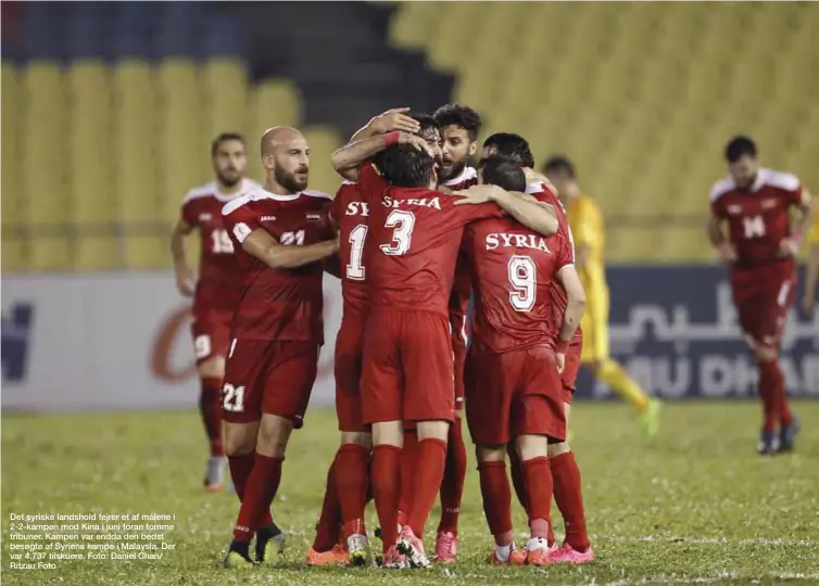  ??  ?? Det syriske landshold fejrer et af målene i 2-2-kampen mod Kina i juni foran tomme tribuner. Kampen var endda den bedst besøgte af Syriens kampe i Malaysia. Der var 4.737 tilskuere. Foto: Daniel Chan/ Ritzau Foto